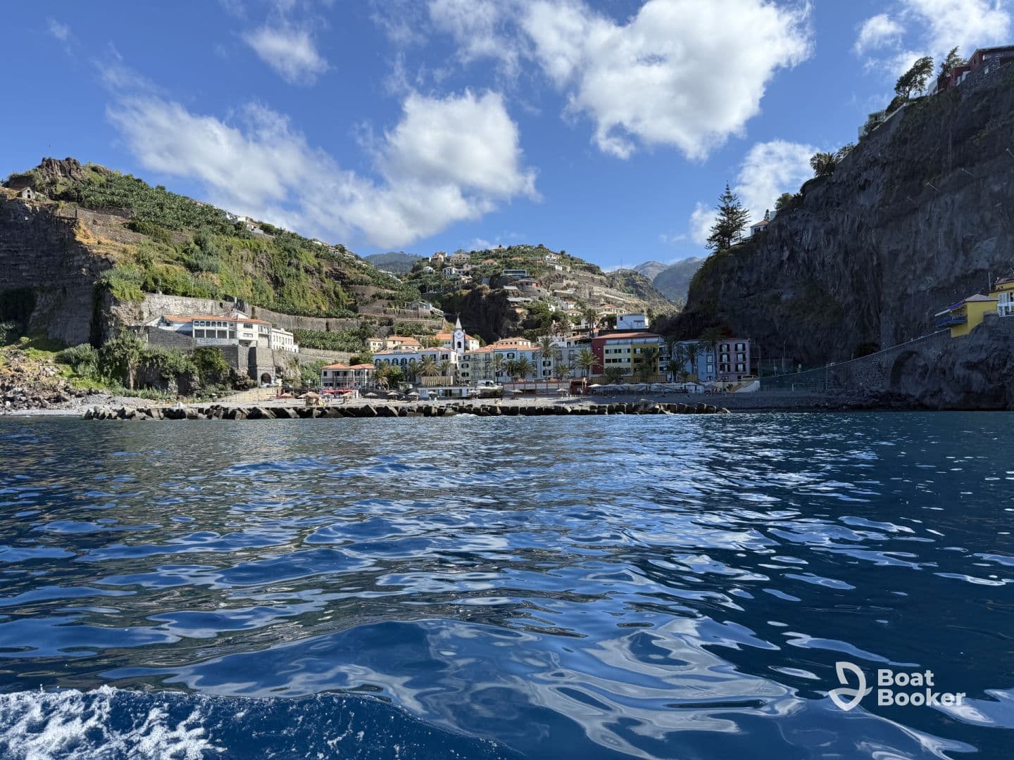 A stunning view of a coastal town nestled against the mountains, showcasing beautiful architecture and a serene harbor — perfect for exploring the scenic beauty of the region.