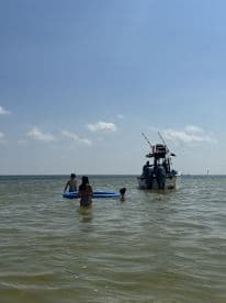 A group of children enjoys a fun day swimming in shallow waters near a boat, perfect for family outings and water activities.