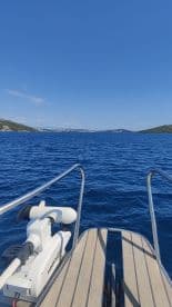 A clear view of the boat's bow with the tranquil blue waters and distant islands in the background, perfect for showcasing boating adventures.
