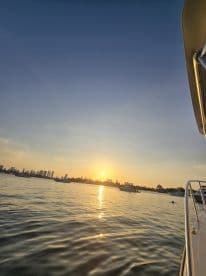 A stunning sunset view from a boat, showcasing the city skyline reflected on the water — perfect for evening cruises and scenic experiences.