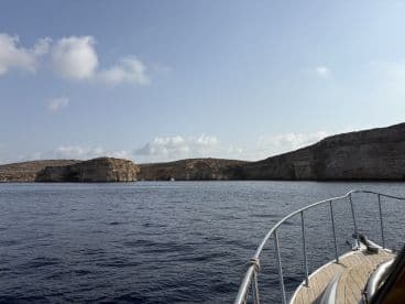 A scenic view from the deck of a boat, showcasing stunning cliffs and calm waters, perfect for exploring coastal landscapes.