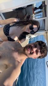 A cheerful couple takes a selfie on a boat, enjoying their time on the ocean — perfect for capturing memorable moments during a day on the water.