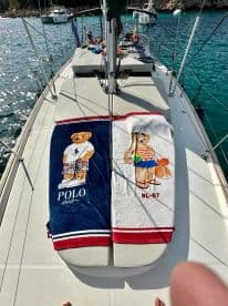 Colorful towels laid out on the deck of a sailboat, perfect for sunbathing and enjoying a day on the water.