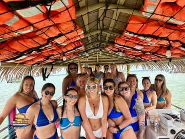 A lively group of friends enjoys a fun day on the water, celebrating together on a boat — perfect for bachelorette parties or girls' trips.