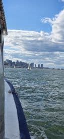 A scenic view of sailboats navigating the water with a stunning city skyline in the background, perfect for showcasing urban sailing adventures.