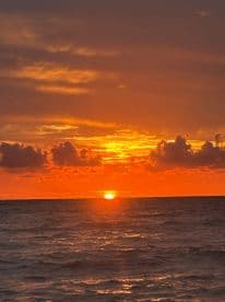 A breathtaking sunset over the ocean, showcasing vibrant hues of orange and gold — a perfect backdrop for romantic evenings or serene boat trips.