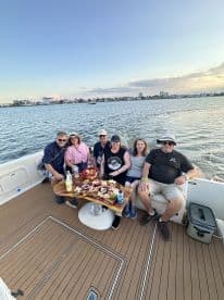 A cheerful group enjoys a delicious spread aboard a boat, perfect for celebrations and gatherings on the water.