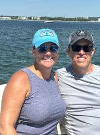 A happy couple enjoys a sunny day on the water, capturing a memorable moment while boating. Perfect for showcasing fun outings and romantic adventures.