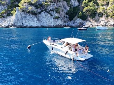 A lively group enjoys a day on the water aboard a boat, surrounded by stunning coastal scenery — perfect for summer adventures and relaxation.