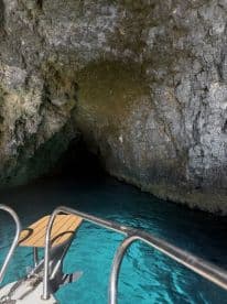A stunning view from the bow of a boat entering a cave, surrounded by crystal-clear turquoise waters — a perfect spot for adventure seekers exploring hidden gems.