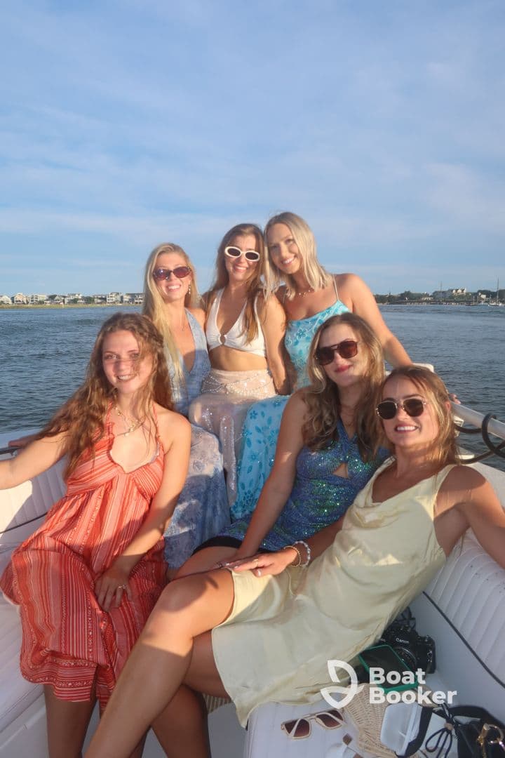 A lively group of friends poses for a fun photo on a boat, perfect for summer celebrations and memorable outings on the water.