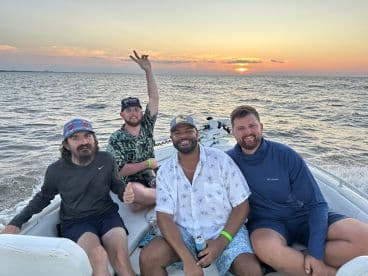 A group of friends enjoys a sunset boat ride, capturing the essence of fun and camaraderie on the water.