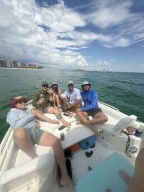 A lively group of friends enjoys a day on the water, celebrating and relaxing on a boat — perfect for summer outings and memorable adventures.