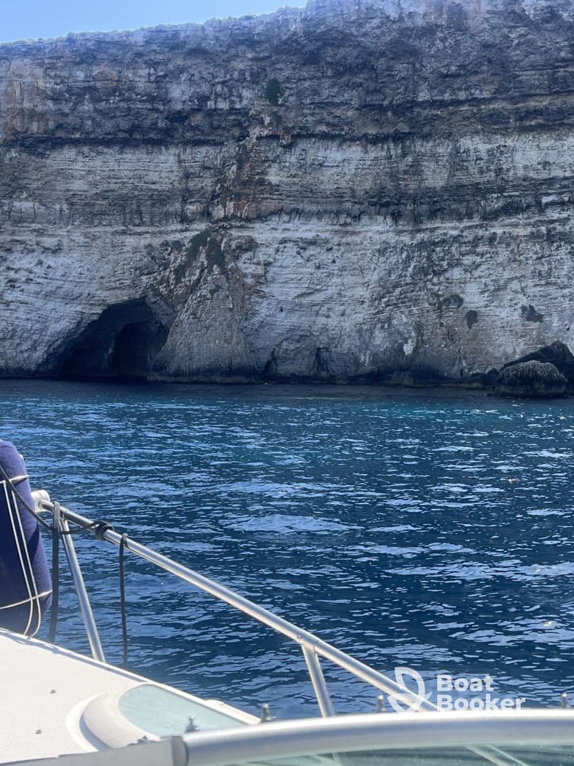 A stunning view of a rocky coastline with a cave, captured from a boat — perfect for showcasing the natural beauty of the area.