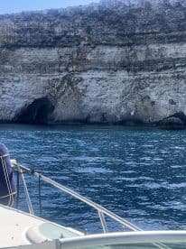 A stunning view of a rocky coastline with a cave, captured from a boat — perfect for showcasing the natural beauty of the area.