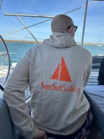 A guest enjoys a sailing experience aboard a boat, showcasing the SunSetSailing brand — perfect for memorable outings on the water.