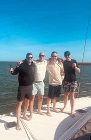 A group of friends enjoys a sunny day on a yacht, celebrating together with drinks in hand — perfect for memorable outings and adventures on the water.