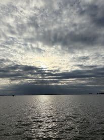 A scenic view of a cloudy sky reflecting on the water, creating a serene atmosphere. Ideal for capturing the beauty of nature.