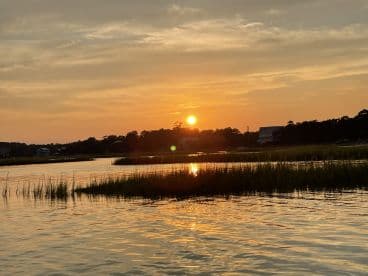 A stunning sunset over tranquil waters, showcasing the beauty of the coastline and perfect for capturing serene moments on a boating trip.