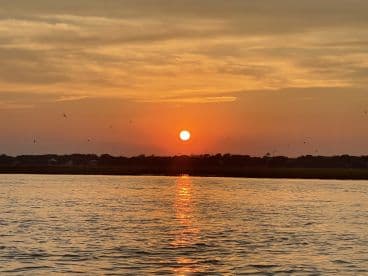A stunning sunset reflects on the water, creating a serene atmosphere perfect for evening boat rides or peaceful moments on the water.
