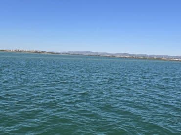 A wide view of water with distant land in the background, lacking clear focus or identifiable features.