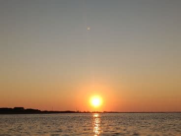 A serene sunset over calm waters, capturing the beauty of the evening sky — perfect for tranquil boating experiences.