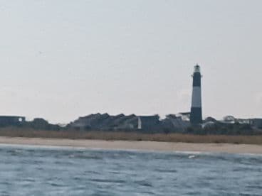 A blurry image of a lighthouse and shoreline, lacking clarity and detail.