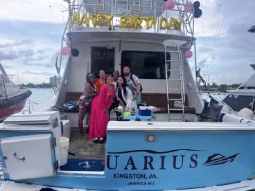 A joyful group celebrates a birthday aboard a boat, complete with festive decorations and a vibrant atmosphere — perfect for memorable party experiences on the water.