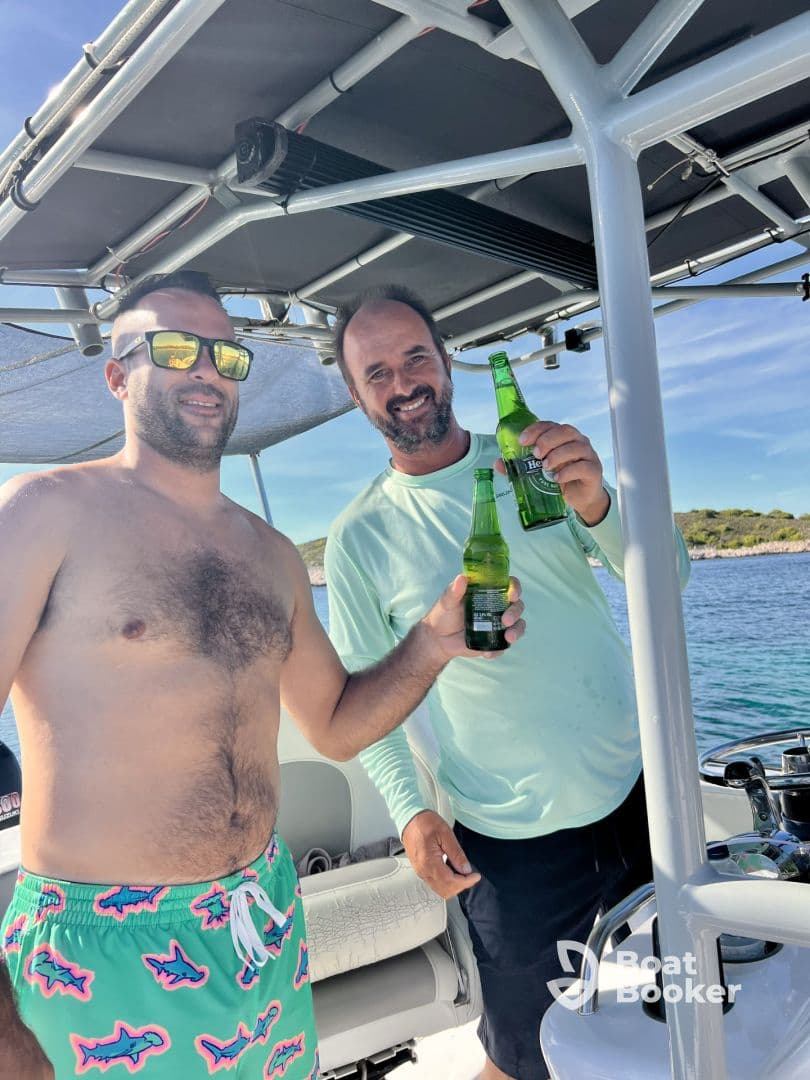 Two friends celebrate with drinks aboard a boat, enjoying a sunny day on the water — perfect for a fun outing or gathering.