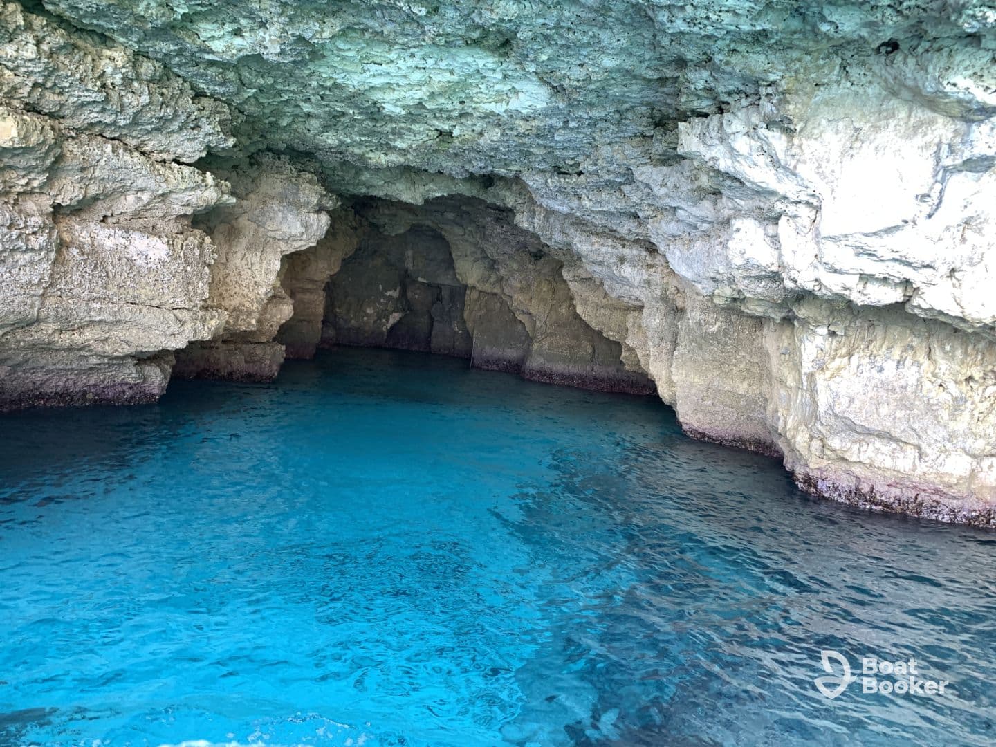 A stunning view of a natural cave with crystal-clear turquoise waters, perfect for exploring coastal wonders and enjoying serene moments on the water.