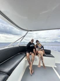 A family enjoys quality time together aboard a boat, surrounded by ocean views — perfect for family outings and adventures on the water.