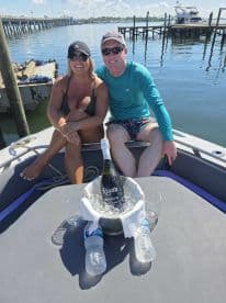 A couple enjoys a sunny day on the boat, celebrating with prosecco and good company — perfect for romantic outings or special occasions on the water.