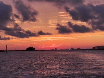 A stunning sunset paints the sky in vibrant hues over the coastline, creating a picturesque backdrop for evening boat trips and romantic cruises.