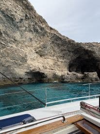 A stunning view of rocky cliffs and turquoise waters, showcasing the natural beauty of the coastline — perfect for exploring hidden caves and enjoying scenic boat trips.
