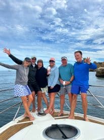 A cheerful group of friends celebrates aboard a boat, enjoying drinks and the beautiful scenery — perfect for memorable outings on the water.