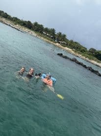 A group of friends enjoys snorkeling in clear waters, showcasing a fun beach day experience perfect for adventure seekers.