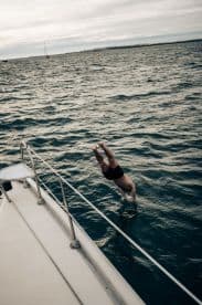 A person dives into the water from a boat, capturing the thrill of on-water activities — perfect for adventure seekers enjoying a day at sea.
