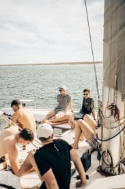A group of friends relaxes on a sailboat, enjoying a sunny day on the water — perfect for social outings and memorable adventures.
