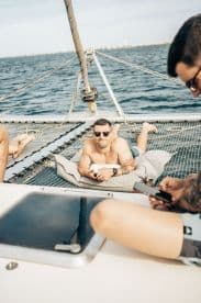 A group of friends relaxes on a catamaran, enjoying the sun and sea while sailing — perfect for a laid-back day on the water.