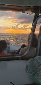 Guests enjoy a stunning sunset view from the comfort of a boat, creating a perfect backdrop for memorable moments on the water.