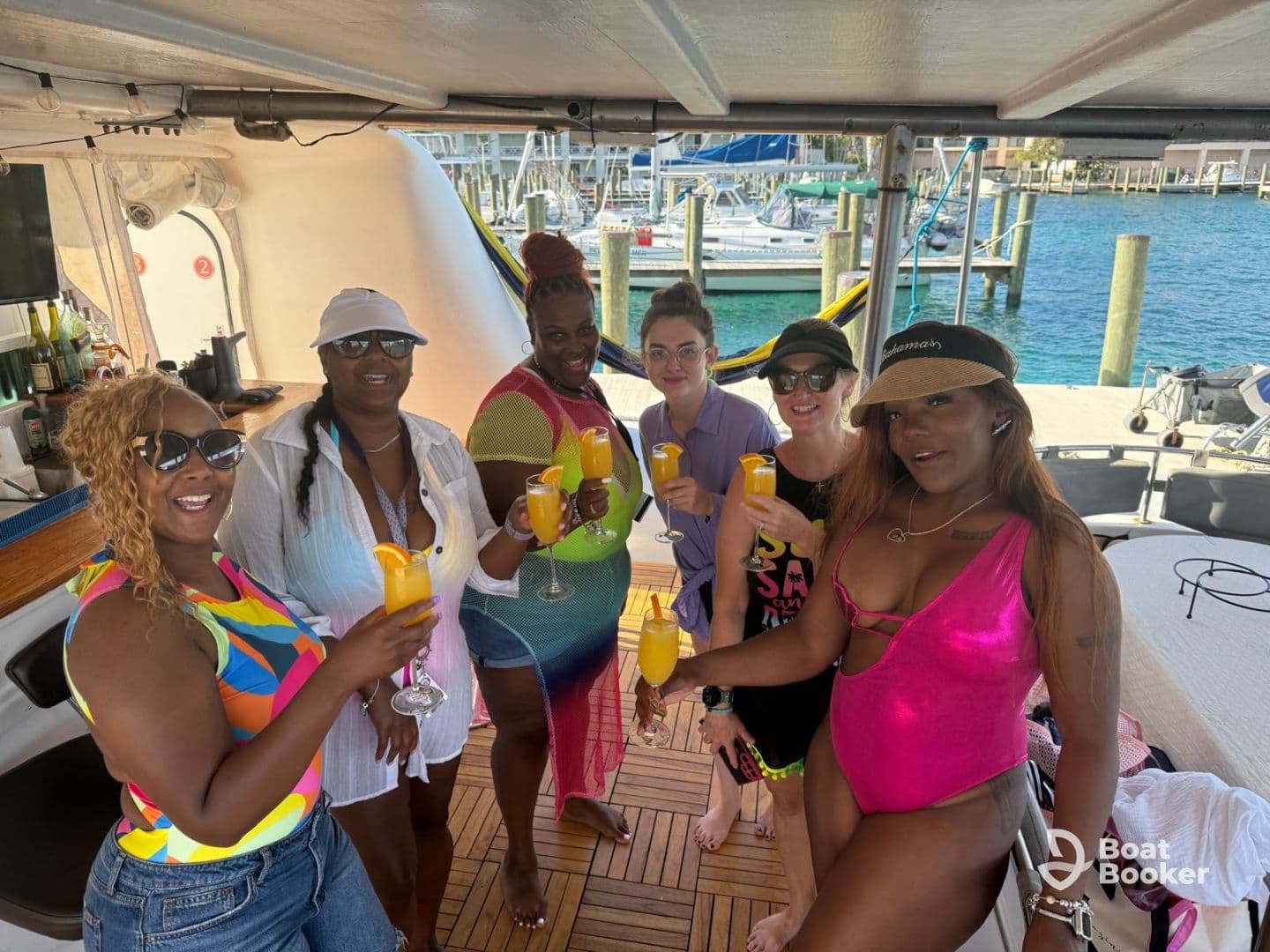 A vibrant group of friends enjoys cocktails aboard a boat, celebrating together in a lively atmosphere — perfect for unforgettable boat parties in the Bahamas.