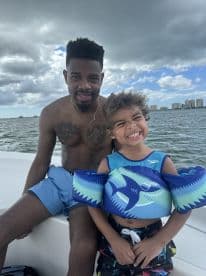 A joyful moment captured of a man and a child enjoying a day on the water, showcasing the fun and bonding experiences that boating can offer.