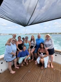A joyful group of friends gathers on the deck of a boat, enjoying their time together in the beautiful waters — perfect for celebrations and memorable outings.
