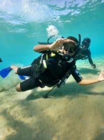 Two divers explore the vibrant underwater world, showcasing the excitement of snorkeling adventures in crystal-clear waters.