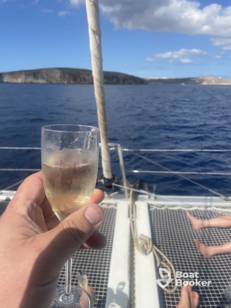 A guest raises a glass of champagne while enjoying a scenic sailing trip, capturing the essence of celebration on the water.