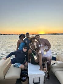 A joyful group of friends celebrates at sunset on a boat, enjoying cocktails and each other's company — perfect for memorable gatherings on the water.