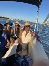 A joyful group of friends enjoys a sunny day on the water, capturing the essence of friendship and fun aboard a boat.