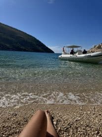 A serene beach scene featuring a boat anchored nearby, perfect for a relaxing day on the water. Enjoy the stunning views and tranquility of this coastal getaway.