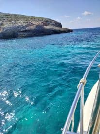 A stunning view from a boat showcasing the clear turquoise waters and rocky coastline, perfect for exploring scenic destinations.