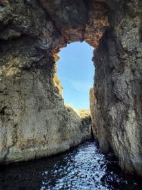 A stunning view through a natural rock arch, showcasing the beautiful scenery and unique geological formations — perfect for exploring coastal landmarks.